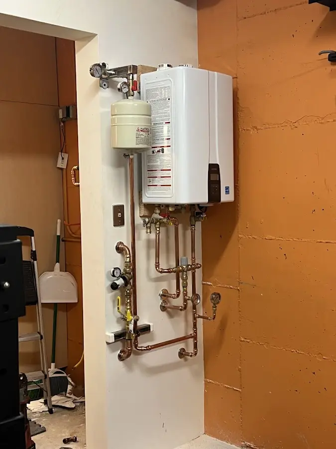 Plumbing technician inspecting water heater connections in Kingsland